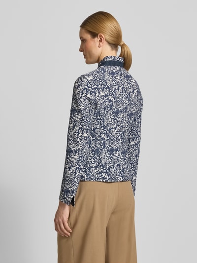 Modelka kobieca nosi Slim Fit Blazer im Allover-Look mit Stehkragen od WHITE LABEL, mieszanka bawełny, wzór na całej powierzchni, krój slim fit, stójka, listwa guzikowa, długość tyłu w rozmiarze 36: 62 cm, szerokość w rozmiarze 36: 46 cm, długość rękawów w rozmiarze 36: 63 cm, odcień granatowo-biały, faktura miękka, widok całej sylwetki z tyłu