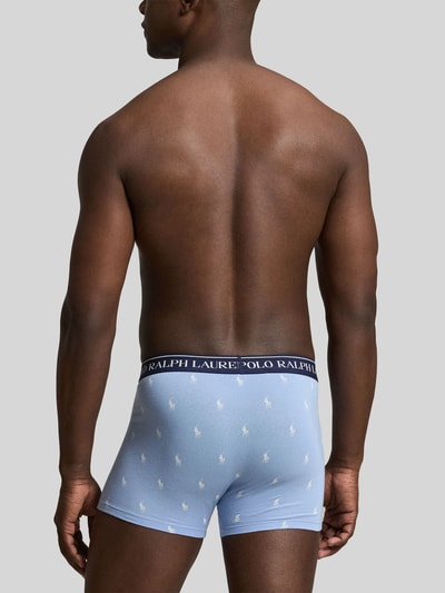Männermodel trägt hellblaue Trunks aus Baumwoll-Mix Modell 'CLSSIC TRUNK-3 PACK' von Polo Ralph Lauren Underwear, Ganzkörperansicht Rückansicht.