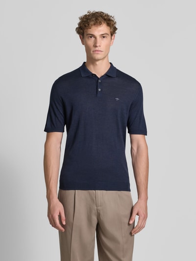 Męski model nosi Regular Fit Poloshirt aus reiner Baumwolle in Strick-Optik von Fynch-Hatton, granatowa, krój regular fit, kołnierzyk polo, z krótkim rękawem, imitacja dzianiny, długość tyłu w rozmiarze M: 67 cm, widok całej sylwetki z przodu.