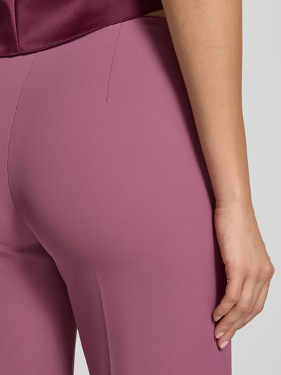 Vrouwenmodel draagt Flared Fit Hose mit Bundfalten van Rinascimento in lila, elastische materiaalmix, naadritssluiting, detailopname.