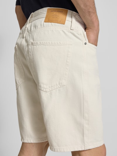 Männermodel trägt Loose Fit Jeansshorts mit Eingrifftaschen Modell 'TONY' von Jack & Jones in Creme, Reine Baumwolle, Used-Look, Ganzkörperansicht Rückansicht.