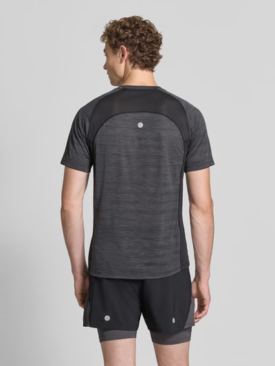 Męski model nosi Regular Fit T-Shirt mit Logo-Print Modell 'Road' od ASICS TIGER, półprzejrzysty materiał, okrągły dekolt, Długość tyłu w rozmiarze M: 69 cm, widok całej sylwetki od tyłu.