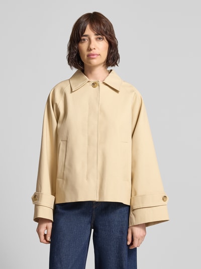 Frauenmodel trägt Jacke mit Ärmelriegeln Modell 'CUBA' von Mango in Beige, reine Baumwolle, Relaxed Fit, Ganzkörperansicht von vorne.