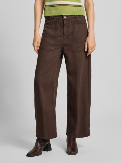 Kobiece model prezentuje Barrel Fit Hose mit Eingrifftaschen Modell 'DERIVE' von DRYKORN, mieszanka lyocellu i lnu, kolor brązowy, wpuszczane kieszenie, szerokość w rozmiarze 27/34: 41 cm, długość wewnętrzna nogawki: 69 cm, spodnie o luźnym kroju, widok całej sylwetki z przodu.