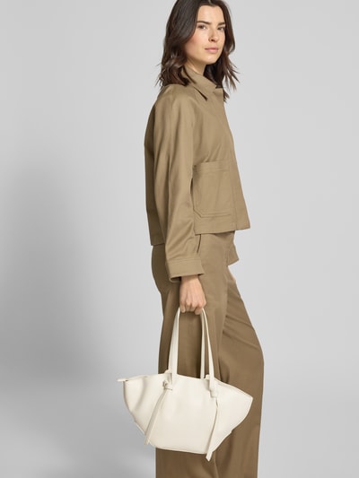 Frauenmodel trägt Shopper mit Label-Detail Modell 'RYD' von Seidenfelt in Beige, Hauptfach mit Reißverschluss, Schulterriemen, Ganzkörperansicht von vorne. Breite 40 cm, Länge 23 cm, Tiefe 12 cm, Riemenlänge 59 cm.