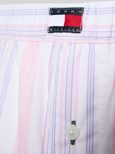 Frauenmodel trägt Loose Fit Pyjama-Hose aus reiner Baumwolle von TOMMY HILFIGER, Optik:Allover-Muster in gestreift, Zierknopf, Label-Patch, Bundabschluss elastisch, Popeline, Detailaufnahme.