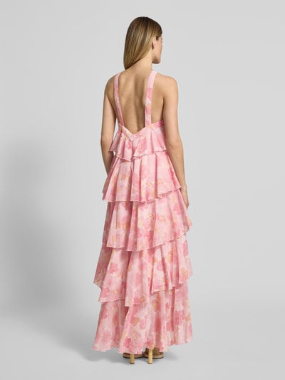 Frauenmodel trägt Volant Abendkleid mit V-Ausschnitt Modell 'FELICIA' von Vero Moda, rosa, aus Chiffon, Maxi-Länge, Ganzkörperansicht Rückansicht.
