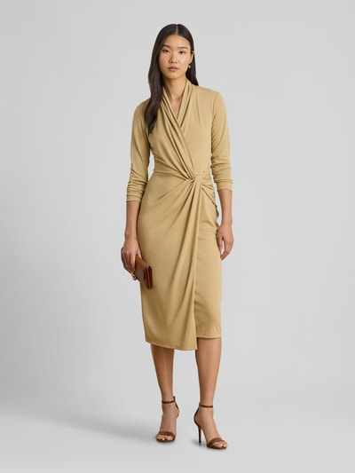 Frauenmodel trägt knielanges Kleid in Wickeloptik von Lauren Ralph Lauren in Beige, eng anliegend, V-Ausschnitt, Ganzkörperansicht von vorne.