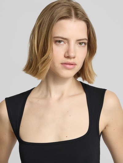 Frauenmodel trägt Top mit Karree-Ausschnitt Modell 'ISABELLA GIGI' von JJXX aus schwarzem Baumwoll-Mix mit Stretch-Anteil, Nahaufnahme Oberkörper.