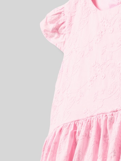 Mädchen trägt Kleid mit Stitchings Modell 'SANGALLO' von Guess, rosa Baumwolle, A-Linie, Rundhalsausschnitt, Nahaufnahme Oberkörper.