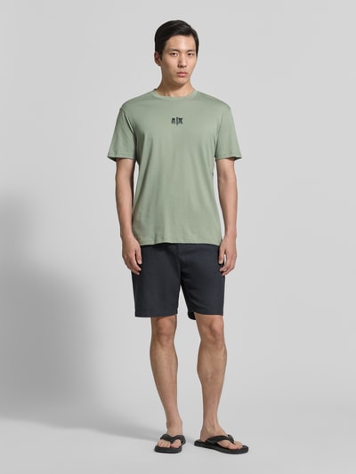 Mannenmodel draagt T-shirt met logo en ronde hals van ARMANI EXCHANGE, puur katoen, regular fit, ruglengte maat M 82 cm, geheel van voren.
