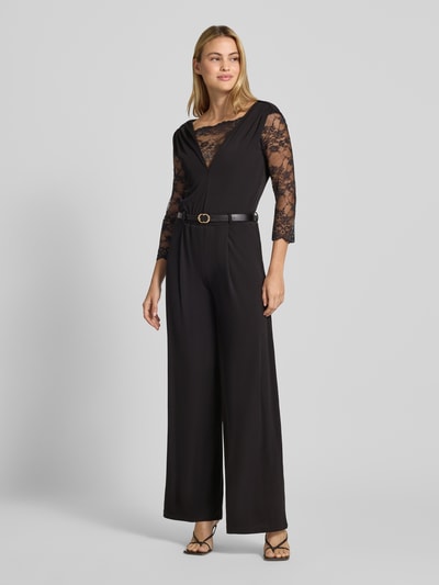 Frauenmodel trägt Regular Fit Jumpsuit mit Spitzenbesatz von Rinascimento in Schwarz, V-Ausschnitt, 3/4-Arm, Ganzkörperansicht von vorne. Damen Jumpsuit von Rinascimento, Spitzenbesatz, Regular Fit, V-Ausschnitt, Raffungen, 3/4-Arm, Rückenlänge bei Größe S: 37 cm, Brustweite bei Größe S: 36 cm, Ärmellänge bei Größe S: 47 cm, Gesamtlänge bei Größe S: 158 cm, Innenbeinlänge bei Größe S: 87 cm.