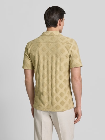 Männermodel trägt Slim Fit Poloshirt mit Strukturmuster von Fynch-Hatton aus Baumwoll-Mix, Reverskragen, Rückenlänge 74 cm, Ganzkörperansicht Rückansicht.
