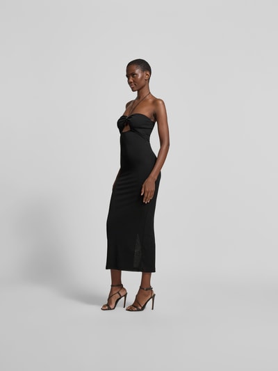 Frauenmodel trägt Slim Fit Midikleid mit Zierstein-Detail von Nanushka in Schwarz, Gehschlitz, Cut-Out, Neckholder, Ganzkörperansicht von vorne. Gesamtlänge 117 cm, Brustweite 33 cm, Taillenweite 29 cm.