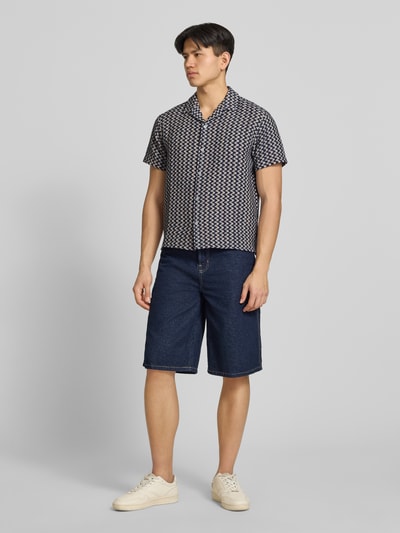 Männermodel trägt Regular Fit Freizeithemd im Allover-Look Modell 'MONTAUK' von Jack & Jones, Kurzarm, Dunkelblau gemustert, Ganzkörperansicht von vorne, Material-Mix mit Baumwoll-Anteil, Reverskragen, Knopfleiste.