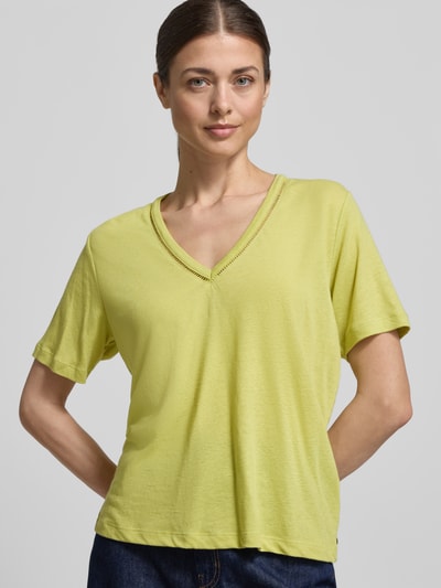 Frauenmodel trägt Regular Fit T-Shirt aus Leinen-Mix mit V-Ausschnitt von Scotch & Soda, Lochmuster, Rückenlänge 62 cm, Nahaufnahme Oberkörper.