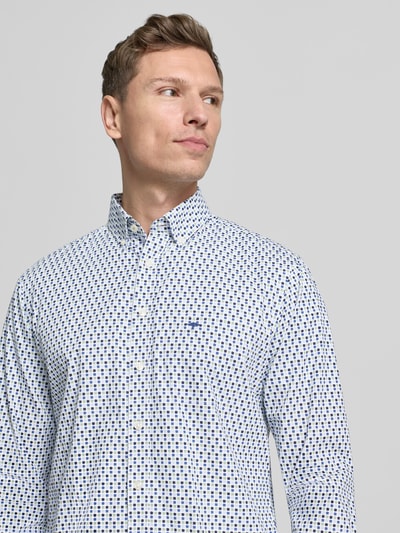 Männermodel trägt Slim Fit Freizeithemd mit Logo-Stitching von Fynch-Hatton, weiß-blau gemustert, reine Baumwolle, Nahaufnahme Oberkörper.