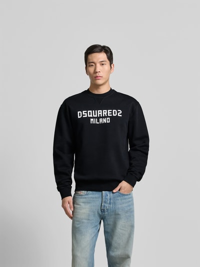 Männermodel trägt Cool Fit Sweatshirt aus reiner Baumwolle von Dsquared2 mit Label-Print, Schwarz, Ganzkörperansicht von vorne.