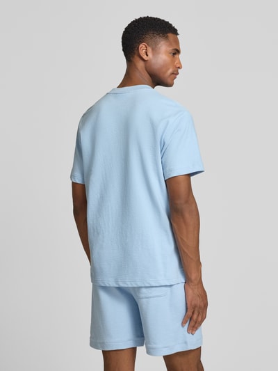 Männermodel trägt Regular Fit T-Shirt aus reiner Baumwolle von Lacoste, unifarben, feinstrick, kurzarm, Ganzkörperansicht Rückansicht.