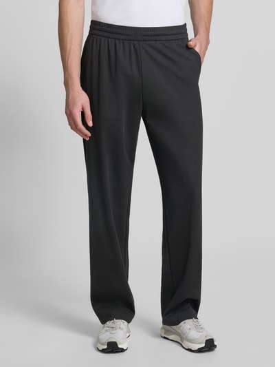 Männermodel trägt schwarze Sweatpants mit elastischem Bund von Emporio Armani, Lyocell-Mix mit Viskose-Anteil, Relaxed-Fit, Eingrifftaschen, Herren, Ganzkörperansicht von vorne.