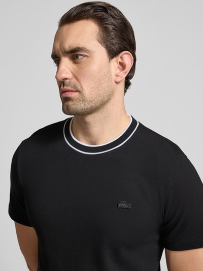 Männermodel trägt Regular Fit T-shirt aus katoenmix van Lacoste, look: effen, logostitching, ronde hals, korte mouw, piqué, Nahaufnahme Oberkörper.