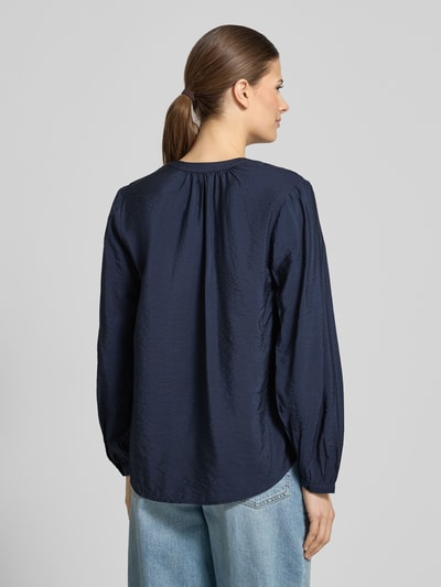 Vrouwenmodel draagt Relaxed Fit Langarmbluse aus Viskose-Mix van s.Oliver RED LABEL in donkerblauw, afgeronde rompzoom, tuniekkraag, V-hals, lange mouwen met smalle manchet, viscosemix, Ganzkörperansicht Rückansicht.