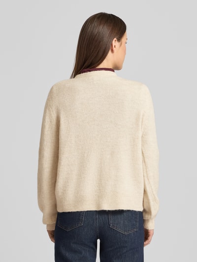 Frauenmodel trägt Strickjacke mit Knopfleiste Modell 'NIMMA' von B.Young im Material-Mix mit Lanawoll-Anteil, Regular-Fit, Gerippte-Abschlüsse, Rundhalsausschnitt, Rückenlänge 57 cm, Ärmellänge 63 cm, einfarbig in Beige, strukturierte weiche Oberfläche, Ganzkörperansicht Rückansicht.