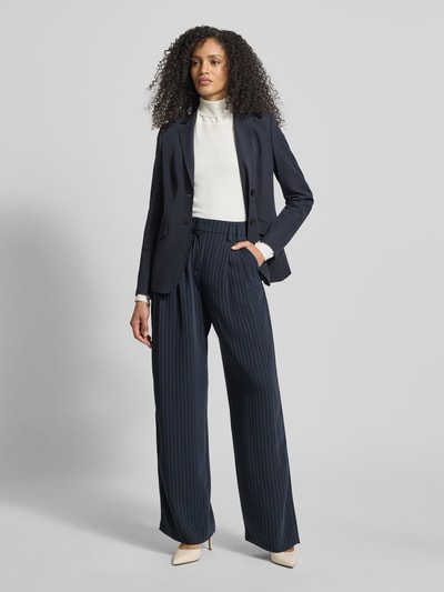 Vrouwenmodel draagt stoffen broek met materiaalmix met viscose, los model, Franse steekzakken, Model 'MAYLA' van Raffaello Rossi, volledig vooraanzicht.