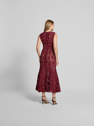 Vrouwenmodel draagt Maxikleid aus floraler Spitze van Self-Portrait in bordeauxrood, elastische materiaalmix, slim fit, bloemenkant, afneembare tailleband, mouwloos design, totale lengte bij maat S 137 cm, borstwijdte 40 cm, taillewijdte 34 cm. Volledige lichaamsaanzicht achteraan.