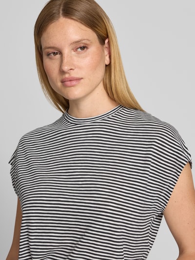 Vrouwenmodel draagt Loose Fit T-shirt uit puur katoen van Armedangels met gestreept motief, tweekleurige look, ronde hals, mouwloos design, jersey materiaal, labelpatch en logostitching, Nahaufnahme bovenlichaam.