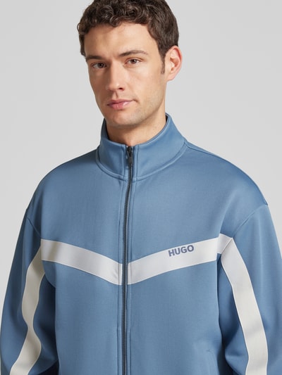 Männermodel trägt Relaxed Fit Sweatjacke mit Chevron-Tape Modell 'DARTI' von HUGO, Optik: Unifarben, Sweat, Nahaufnahme Oberkörper.