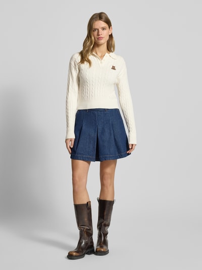 Frauenmodel trägt Slim Fit Poloshirt aus Viskose-Mix Modell 'KATIA' von Only, Optik: Unifarben, Zopfmuster, Stickerei, Strick, Ganzkörperansicht von vorne.