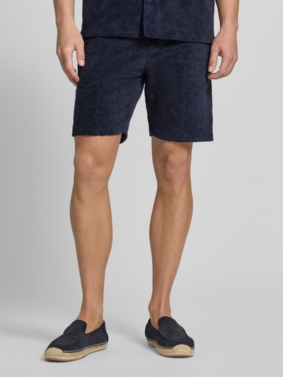 Männermodel trägt Shorts mit Strukturmuster und Eingrifftaschen von MCNEAL in Dunkelblau, Baumwoll-Mix, Nahaufnahme Oberschenkel.