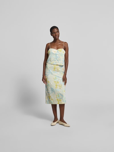Frauenmodel trägt Top mit Allover-Paillettenbesatz von BAUM & PFERDGARTEN im Floralen-Muster, Elastischer-Material-Mix, Regular-Fit, Spaghetti-Träger, sanfte Blau- und Gelbtöne, schimmernde Textur, Rückenlänge 25 cm bei Größe S, Ganzkörperansicht von vorne.