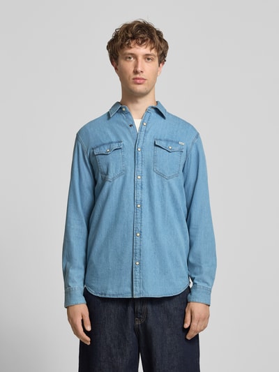 Męski model nosi Slim Fit Freizeithemd mit Kentkragen Model 'ESHERIDAN' von JACK & JONES, bawełna, krój slim fit, niebieski, listwa guzikowa, kieszenie na piersi, detal z logo, Ganzkörperansicht von vorne. Długość tyłu w rozmiarze M: 76 cm, szerokość ramion w rozmiarze M: 42 cm, długość rękawów w rozmiarze M: 65 cm.