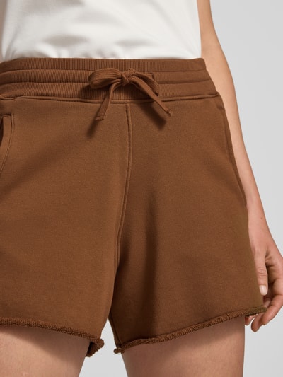 Frauenmodel trägt Sweatshorts mit Eingrifftaschen von Rich & Royal in Braun, aus Baumwoll-Mix mit Stretch-Anteil, Relaxed-Fit, Nahaufnahme Oberkörper.