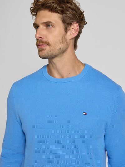 Mężczyznamodel nosi Regular Fit Pullover aus reiner Baumwolle von Tommy Hilfiger, jasnoniebieski, fakturowany materiał, zbliżenie górnej części ciała.