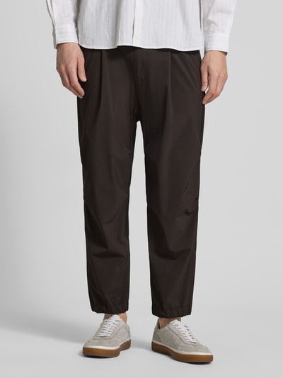 Männermodel trägt Relaxed Fit HOSE mit Bundfalten Modell 'Lirog' von Drykorn in Schwarz, Elastischer-Material-Mix, Nahaufnahme Unterkörper, Herren, Bundweite 41 cm, Innenbeinlänge 62 cm, Eingriff- und Gesäßtaschen, Knopf-Reißverschluss.