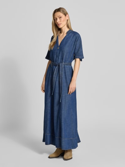 Vrouwenmodel draagt midi-jurk uit lyocellmix model 'Arge' van MOS MOSH, getailleerde pasvorm, met korte mouwen, afneembare stoffen riem, opstaande kraag met V-hals, logodetail, ruglengte maat S: 140 cm, borstwijdte maat S: 50 cm, mouwlengte maat S: 35 cm, blauwtint, egale structuur, geheel vooraanzicht.