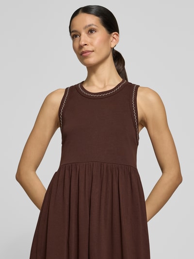 Frauenmodel trägt Midikleid mit Rundhalsausschnitt und Stitchings von Scotch & Soda aus Reine Baumwolle, A-Linie, Nahaufnahme Oberkörper.