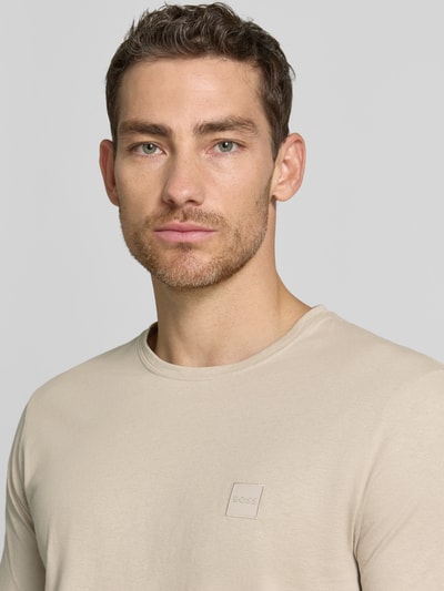 Männermodel trägt Regular Fit T-Shirt aus reiner Baumwolle Modell 'TALES' von BOSS Orange, Optik: Unifarben, Label-Patch, Kurzarm, Rundhals, Nahaufnahme Oberkörper.
