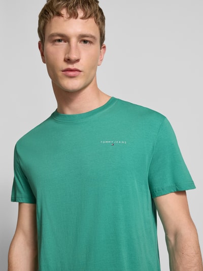 Männermodel trägt Slim Fit T-Shirt aus reiner Baumwolle Modell 'LINEAR CHEST TEE' von Tommy Jeans, Optik: Unifarben, Passform: Regular-Fit, Label-Print, Rundhals, Kurzarm, Material: Reine Baumwolle, Nahaufnahme Oberkörper.