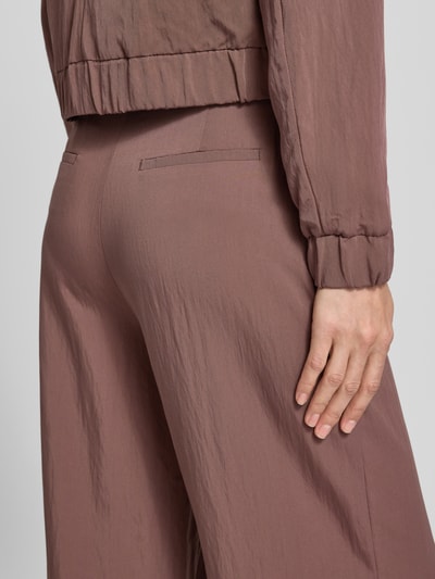 Männermodel trägt Hose mit französischen Eingrifftaschen von Christian Berg Woman Selection, viskoza, krój loose fit, detal z tyłu, zbliżenie na biodra.