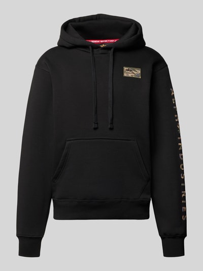 Produktfoto, Hoodie met labelstitching Model 'Camo Sleeve' van Alpha Industries, katoenmix, regular fit, kangoeroezak, zwart met camouflagedetails.