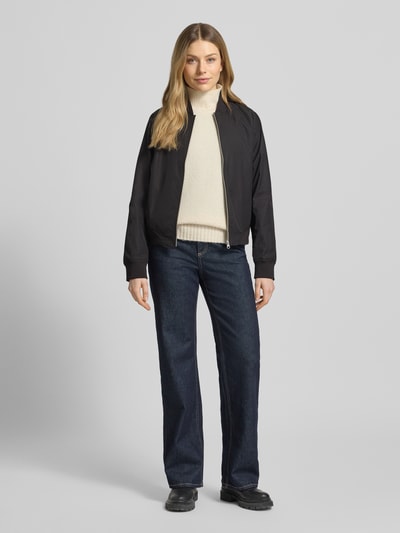 Frauenmodel trägt Regular Fit Jacke mit Stehkragen Modell 'Zaymi' von CARS JEANS, in Schwarz, mit Eingrifftaschen, Reißverschluss, Elastische Abschlüsse, Ganzkörperansicht von vorne. Rückenlänge bei Größe S: 61 cm, Schulterbreite: 41 cm, Brustweite: 39 cm, Ärmellänge: 60 cm.