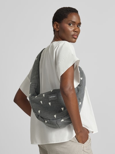 Kobiece model nosi Shoulder Bag aus reiner Baumwolle in Denim-Optik von Studio Noos, tkanina stylizowana na denim, nadruk z motywem na całej powierzchni, detal z logo, główna przegroda z zamkiem błyskawicznym, pasek na ramię, szerokość w rozmiarze 1: 38 cm, długość w rozmiarze 1: 20 cm, głębokość w rozmiarze 1: 8 cm, długość paska na ramię w rozmiarze 1: 86 cm, kolor szary z białym wzorem, widok całej sylwetki z tyłu