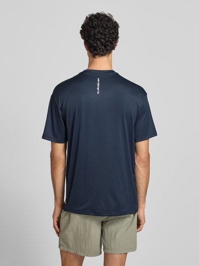 Männermodel trägt T-Shirt mit Rundhalsausschnitt und Logo von Quiksilver, Material-Mix mit Stretch-Anteil, Regular-Fit, Rückenlänge 75 cm, Ganzkörperansicht Rückansicht.