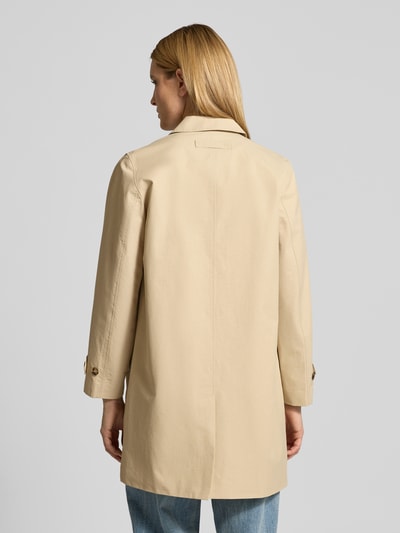 Vrouwenmodel draagt Mantel met verdekte knoopsluiting en mouwsluitingen van Gant, dames, katoenmix, regular fit, platte kraag, steekzakken, ruglengte maat S 90 cm, schouderbreedte 41 cm, borstwijdte 52 cm, mouwlengte 61 cm, zandkleur, rechte vorm, glad oppervlak, geheel zicht van achteren.