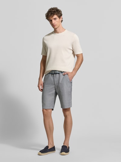 Männermodel trägt Bermudas mit französischen Eingrifftaschen und Gürtel von Christian Berg Men aus Baumwoll-Mix mit Stretch-Anteil, Ganzkörperansicht von vorne.