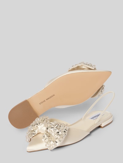 Produktfoto, Slipper mit Ziersteinbesatz Modell 'Sloane' von Steve Madden, spitze Passform, offene Ferse, Zierschleife, glatte Sohle, Absatzhöhe 2 cm, Farbe Creme mit glänzender Textur.